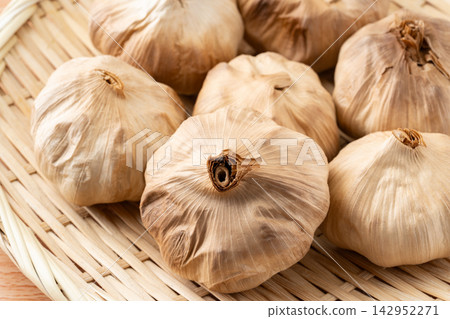 Aged black garlic served in a bamboo basket Aged black garlic served in a bamboo basket 142952271