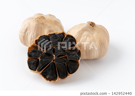 白色背景上的陳年黑蒜頭和黑色橫切面。 142952440