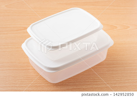 Food storage containers with lids stacked on a wooden table Food storage containers with lids stacked on a wooden table 142952850