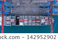 Aerial view of vibrant container ship docked at bustling port with colorful containers, cranes, and tranquil water. global shipping, logistics, and maritime commerce concepts. 142952902