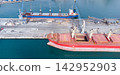 Bustling cargo port with ships, cranes, and equipment at freight terminal. Calm waters showcase efficient maritime logistics and shipping industry operations. transportation and global trade concepts. 142952903