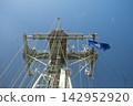Nautical ship mast with NATO flag on clear sky, maritime rigging details, symbolizing unity and international cooperation at sea. 142952920