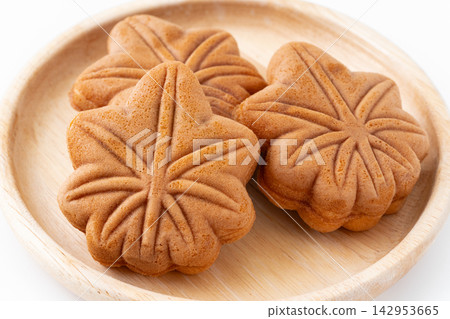 Momiji Manju, a famous Hiroshima specialty, served on a wooden plate against a white background. Momiji Manju, a famous Hiroshima specialty, served on a wooden plate against a white background. 142953665