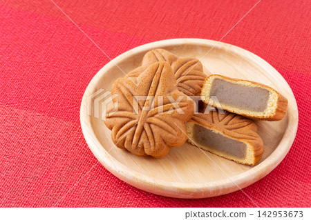 廣島著名的紅葉饅頭盛放在紅色背景的木盤中。 142953673