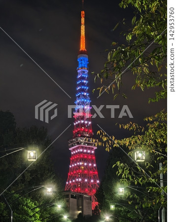 The Tokyo Tower glows red and blue at night. 142953760