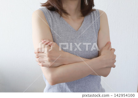 一名女子摀著身體,感到寒冷,四肢冰冷。 一名女子摀著身體,感到寒冷,四肢冰冷。 142954100
