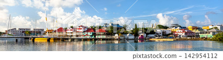 Panoramic waterfront view of Redcliffe Quay in Saint John's harbor, Antigua and Barbuda, featuring colorful buildings and boats under a bright sky. Panoramic waterfront view of Redcliffe Quay in Saint John's harbor, Antigua and Barbuda, featuring colorful buildings and boats under a bright sky. 142954112