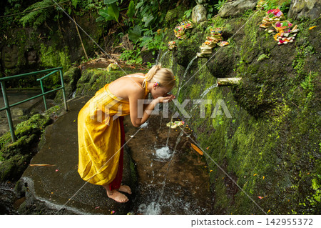 Woman performs purification ritual in sacred water Woman performs purification ritual in sacred water 142955372