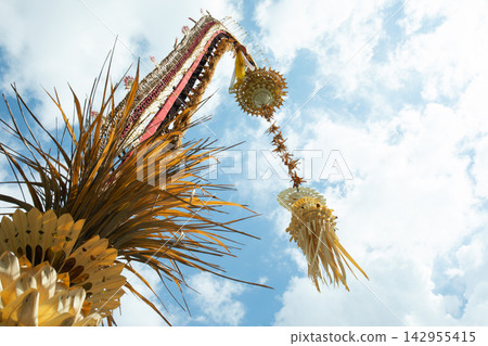 Penjor. Ceremonial penjor stands tall, adorned with vibrant decorations Penjor. Ceremonial penjor stands tall, adorned with vibrant decorations 142955415