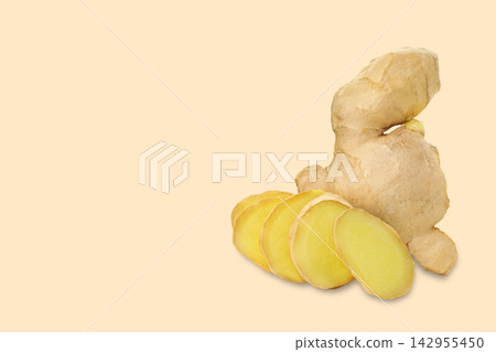 Fresh ginger root sits alongside sliced pieces on soft backdrop 142955450