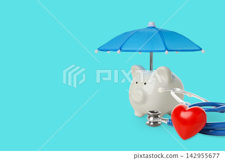 Health insurance. Piggy bank with umbrella alongside stethoscope and red heart Health insurance. Piggy bank with umbrella alongside stethoscope and red heart 142955677