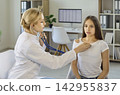 Pediatrician using stethoscope to check girl heartbeat during medical clinic exam 142955837