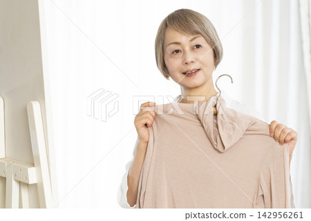 選擇衣裳的資深婦女 選擇衣裳的資深婦女 142956261