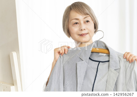 選擇衣裳的資深婦女 選擇衣裳的資深婦女 142956267