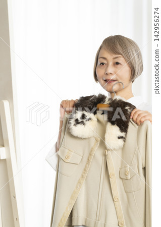 選擇衣裳的資深婦女 選擇衣裳的資深婦女 142956274