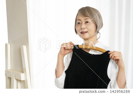 選擇衣裳的資深婦女 選擇衣裳的資深婦女 142956289