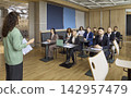 Business team training with coach presenting to employees in modern office classroom 142957479