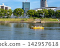 A water taxi operates on the Honkawa River under a clear blue sky. 142957618