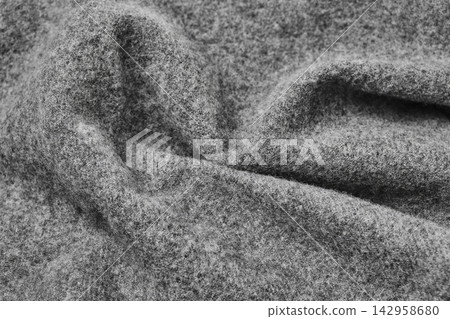 Close-up of soft gray wool felt fabric with deep folds and fuzzy textured surface Close-up of soft gray wool felt fabric with deep folds and fuzzy textured surface 142958680