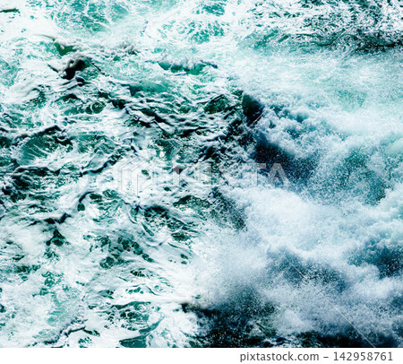 On a windy day, waves crash against the rocks, creating whitecaps and a rough sea scene. On a windy day, waves crash against the rocks, creating whitecaps and a rough sea scene. 142958761