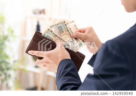 一位年輕的商人，錢包裡裝著錢。 142959540