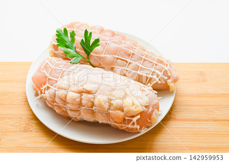 Food preparation: Chicken breast wrapped in string netting Food preparation: Chicken breast wrapped in string netting 142959953