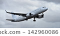 The plane is taking off, passenger airliner. A white plane flies in storm clouds 142960086