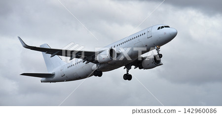 The plane is taking off, passenger airliner. A white plane flies in storm clouds The plane is taking off, passenger airliner. A white plane flies in storm clouds 142960086