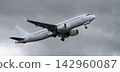 The plane is taking off, passenger airliner. A white plane flies in storm clouds 142960087