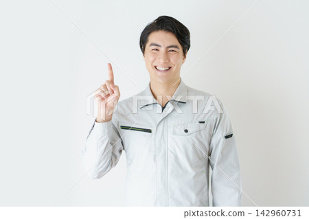 Portrait of a young Japanese man in work clothes against a white background. Portrait of a young Japanese man in work clothes against a white background. 142960731