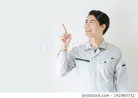 Portrait of a young Japanese man in work clothes against a white background. Portrait of a young Japanese man in work clothes against a white background. 142960732