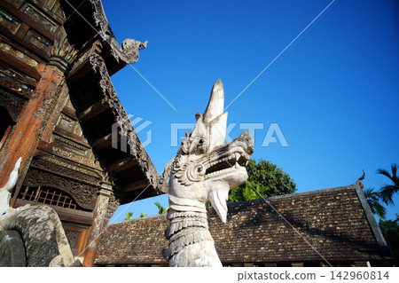 Beautiful white Naga statue and ancient stucco art of Buddhist in architecture lanna temple with blue sky of Chiang Mai in Thailand Beautiful white Naga statue and ancient stucco art of Buddhist in architecture lanna temple with blue sky of Chiang Mai in Thailand 142960814