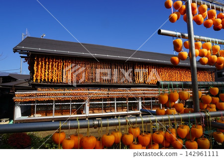 A scene of dried persimmons hanging from the eaves of a house in November, Koshu City, Matsusato area. A scene of dried persimmons hanging from the eaves of a house in November, Koshu City, Matsusato area. 142961111