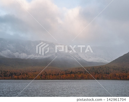 Misty Mountain Lake with Autumn Forest and Snow-Capped Peaks Misty Mountain Lake with Autumn Forest and Snow-Capped Peaks 142961704