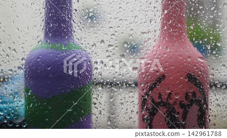 Rain drops on the glass in the spring afternoon. Close up of a window with rain drops falling down.The rain drops on household windows. Focus on rain drops. concept of sadness, frustration Rain drops on the glass in the spring afternoon. Close up of a window with rain drops falling down.The rain drops on household windows. Focus on rain drops. concept of sadness, frustration 142961788