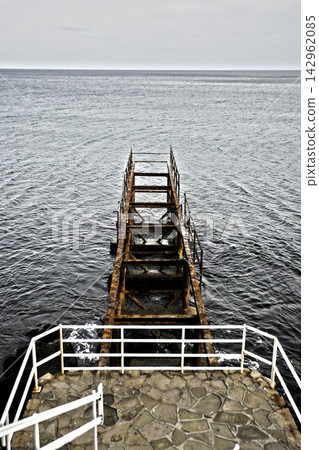 old rusty metal ladder on the sea old rusty metal ladder on the sea 142962085