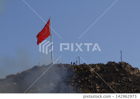 Red raging flame of fire burn in grass fields, forests and black and white smoke to sky. Big wildfire close-up. pollution in air concept. Red raging flame of fire burn in grass fields, forests and black and white smoke to sky. Big wildfire close-up. pollution in air concept. 142962973
