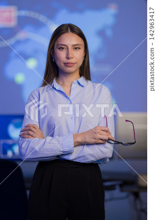 Confident cybersecurity analyst in a technology control room with advanced monitoring tools 142963417