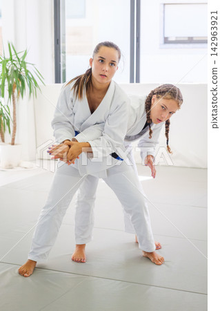 Women drill a standing arm control in a jiu jitsu class Women drill a standing arm control in a jiu jitsu class 142963921