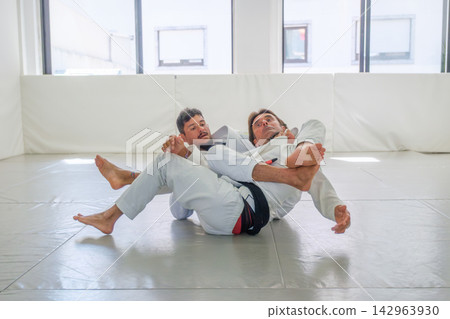 Jiu jitsu practitioners demonstrating a collar choke Jiu jitsu practitioners demonstrating a collar choke 142963930