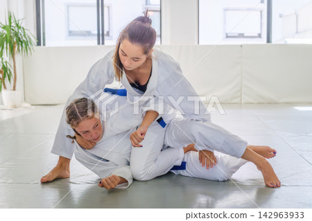 Jiu jitsu students practicing a collar choke with arm control Jiu jitsu students practicing a collar choke with arm control 142963933