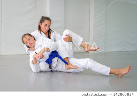 Jiu jitsu students entering a bow and arrow choke Jiu jitsu students entering a bow and arrow choke 142963934