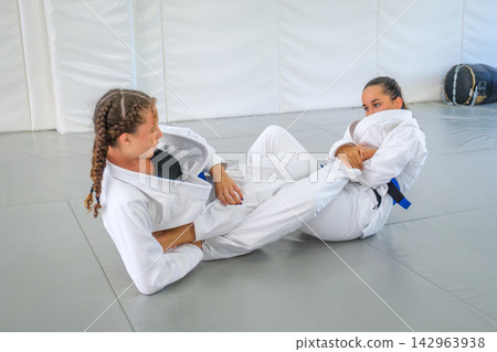 Women practicing a straight foot lock in Brazilian jiu jitsu Women practicing a straight foot lock in Brazilian jiu jitsu 142963938
