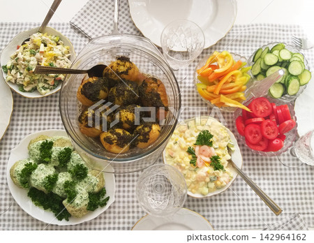 Freshly prepared potatoes, salads, and vegetables on a checkered tablecloth Freshly prepared potatoes, salads, and vegetables on a checkered tablecloth 142964162