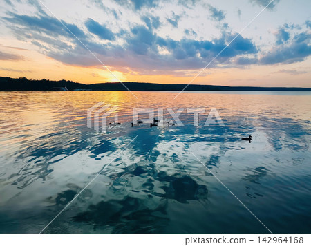 Sunset reflects on calm water Sunset reflects on calm water 142964168