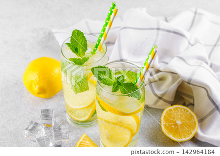 Top view of refreshing homemade lemonade. Fresh mint, lemon slices, ice in glasses, cold beverage Top view of refreshing homemade lemonade. Fresh mint, lemon slices, ice in glasses, cold beverage 142964184