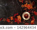 Autumn abstract composition with hot mulled wine, maple leaves, pine cones, nuts, cinnamon, star anise and rowan berries, still life, Thanksgiving concept, seasonal background, banner or splash 142964434
