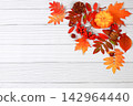 Abstract autumn composition with maple leaves, pine cones, nuts, pumpkins, and rowan berries, still life, Thanksgiving theme, seasonal background, website banner or header, greeting card 142964440