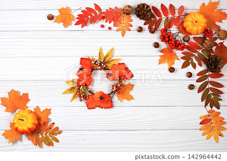 Seasonal banner featuring maple leaves, pine cones, nuts, pumpkins, and rowan berries, Thanksgiving themed still life or website header, an abstract autumn composition for a greeting card Seasonal banner featuring maple leaves, pine cones, nuts, pumpkins, and rowan berries, Thanksgiving themed still life or website header, an abstract autumn composition for a greeting card 142964442