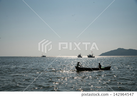 Fishermen - a man and a woman, mother and son, unravel the polluted fishing net and smile, prepare the net for the next fishing Fishermen - a man and a woman, mother and son, unravel the polluted fishing net and smile, prepare the net for the next fishing 142964547